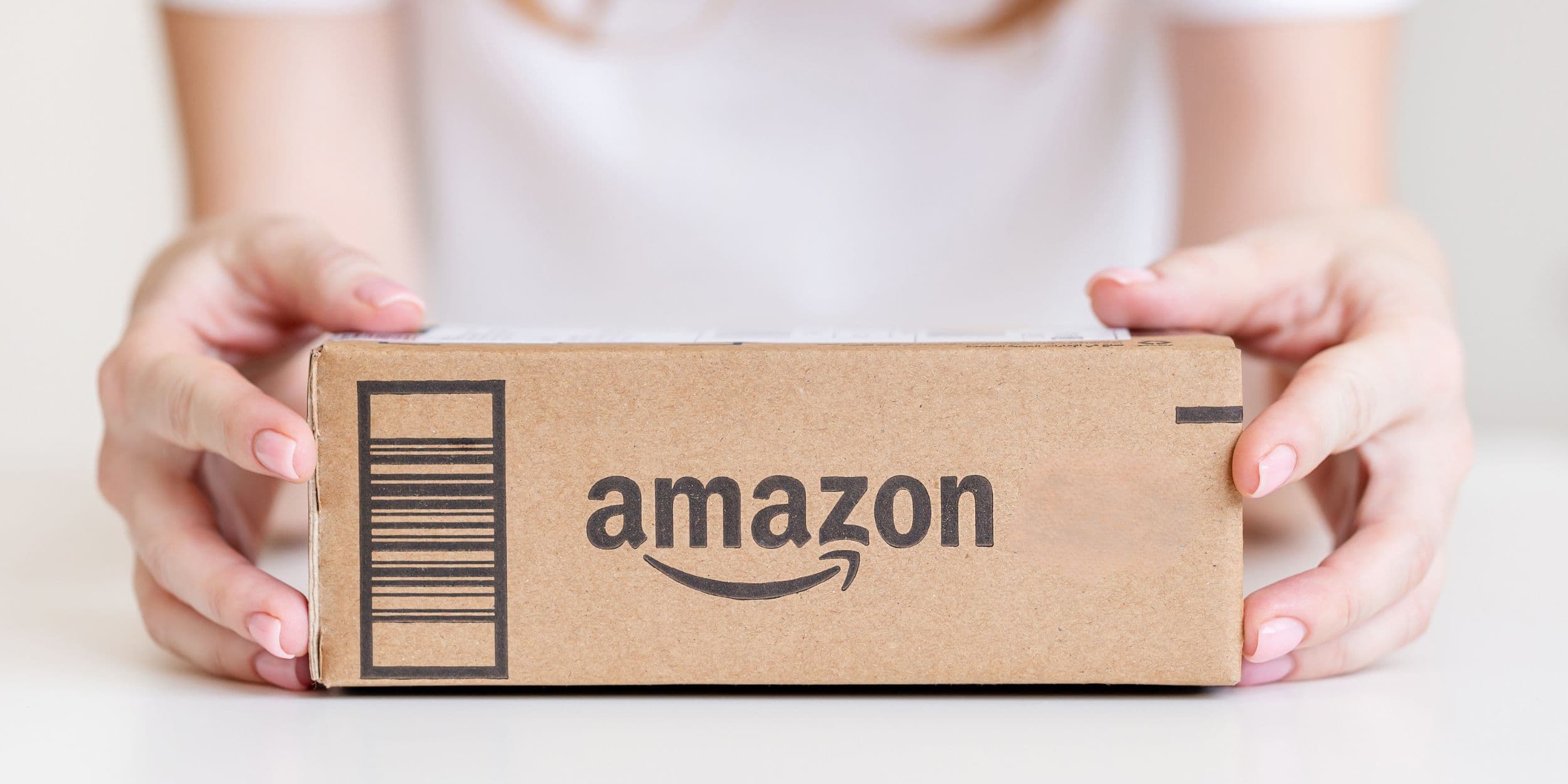 Mani che tengono una scatola di cartone di Amazon 
